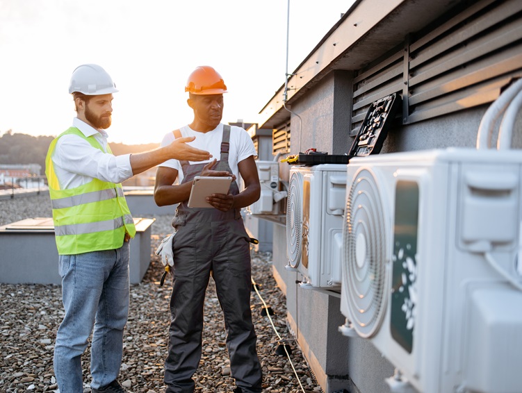 Multicultural males repairing air conditioner using tablet